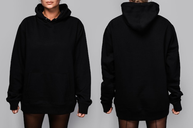 Photo front and back views of a woman wearing a black oversized hoodie with blank space ideal