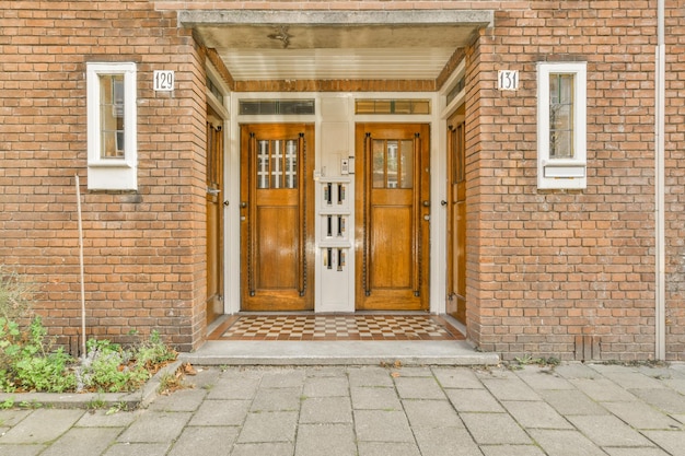 Photo the front of a brick house with two wooden doors