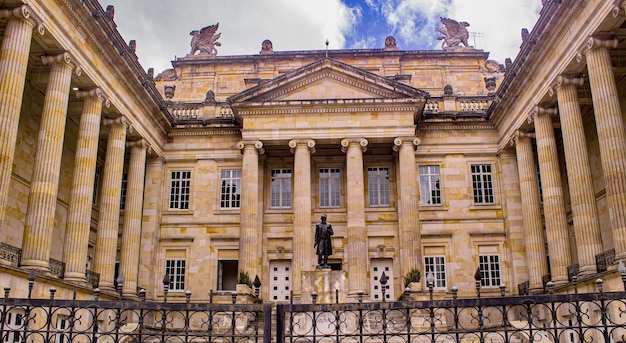 Photo the front of the building is a large stone building with a statue of a man on the front.