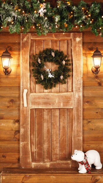 Front door decorated for the holidays. Wooden fairy hut for Christmas