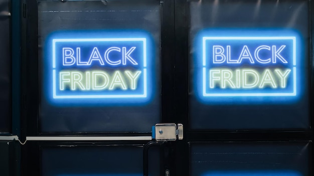 백화점 앞 문은 블랙 프라이데이 (Black Friday) 계절 판매 날, 저렴한 상품과 옷, 특별 제공에 열려 있습니다. 소매점에서 거래와 할인을 보여주는 라벨과 배너.