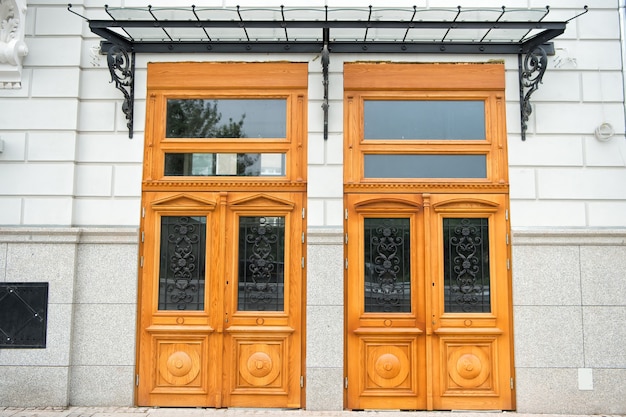 Photo front doors of wood and glass in wroclaw, poland. house entrance on grey wall. architecture, structure, design concept