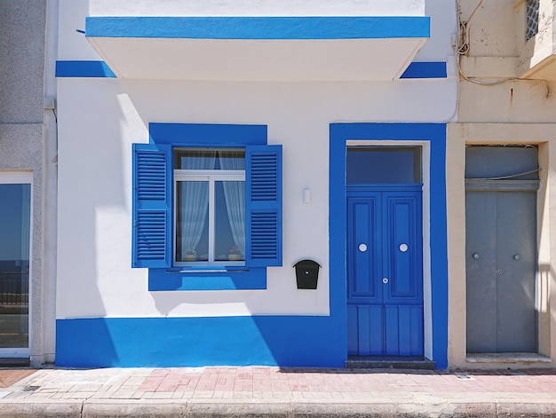 Front facade of residential building with blue door and window