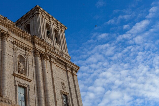 front facade of a Spanish Catholic church with blue sky in the background