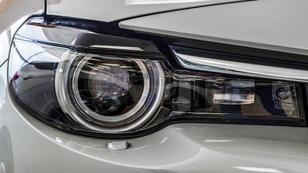 Front headlight of a modern car Light gray color Closeup