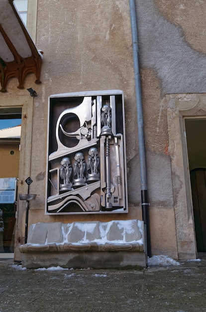 In front of HR Giger Museum in Gruyeres, Switzerland. Birth machine sculpture depicting a crosscut of a gun shooting alien figurines