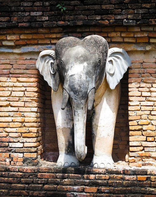 Photo front iew of elephant statue against brick wall