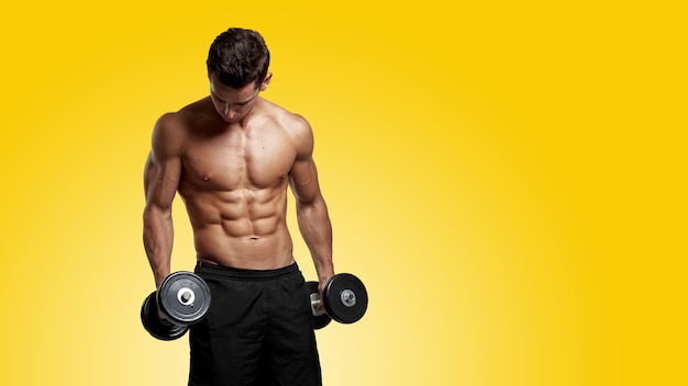 Front image of a confident fit young man shirtless torso training with dumb-bell, showing six pack abs