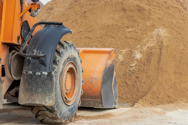 Photo the front loader picks up gravel or crushed stone in the front bucket heavy construction machinery at the construction site transportation of materials at a concrete plant