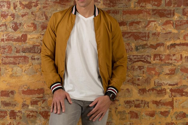 Photo front mid section of a young caucasian man wearing casual street fashion clothes standing against a brick wall