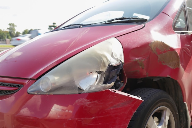 Foto la parte anteriore dell'auto rossa è danneggiata a causa di un incidente stradale