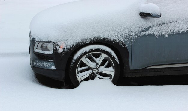 Front Part Of Vehicle Littered With A Large Layer Of Snow On A Street