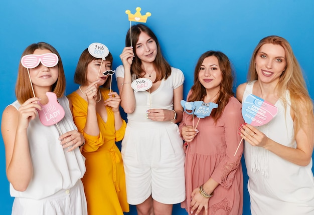 Front photo of a group of smiling women to have gender reveals envent isolated blue background