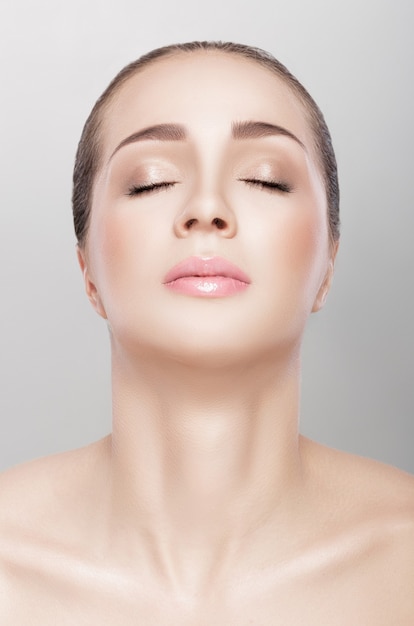 Front portrait of female neck on grey background close up. girl with clean and lifted skin