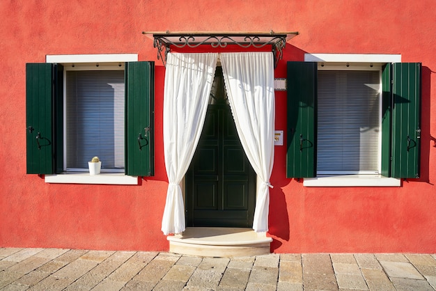 Foto davanti alla casa rossa sull'isola di burano. italia, venezia