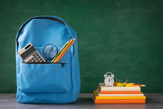 Front of stylish school bag backpack and stationery accessory at the green chalkboard