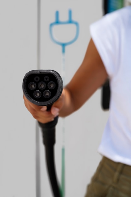 Photo front view adult holding car charger