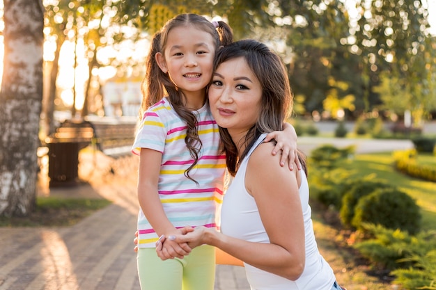 Front view asian mother and daughter holding hands