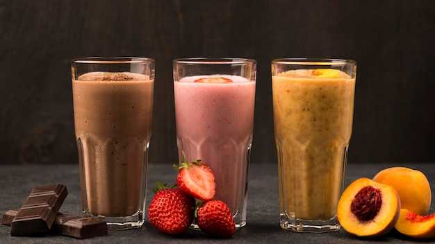 Front view of assortment of milkshakes with fruits and chocolate