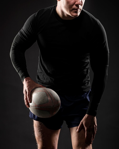 Front view of athletic male rugby player holding ball