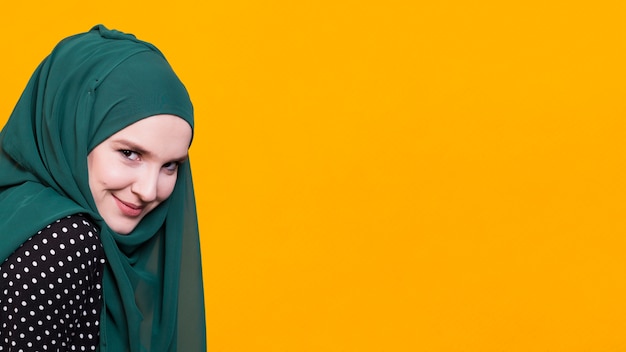 Front view of beautiful woman smiling in front of yellow background