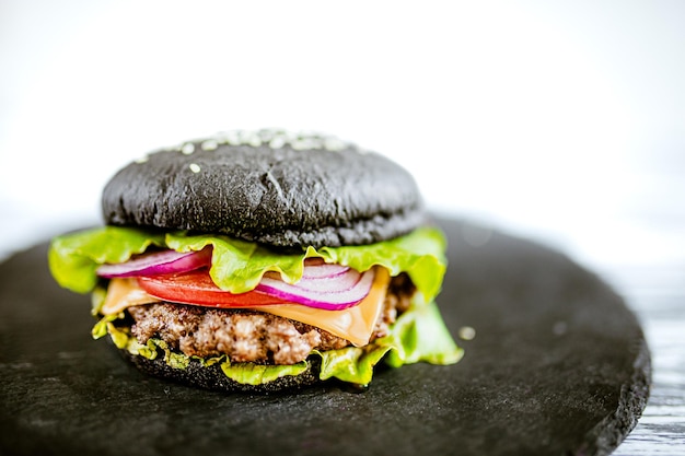 Front view of black burger with artificial meat on stone board Selective focus Vegetarian food