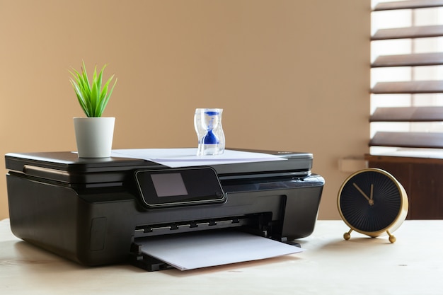 Front view of a black printer machine on a table