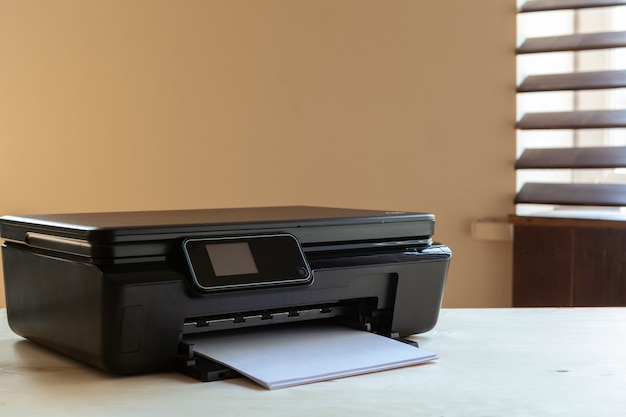 Front view of a black printer machine on a table