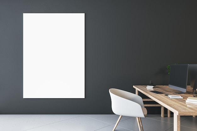 Front view on blank white poster with space for your logo or
text on dark wall background in stylish office with modern computer
on wooden table and light chair on concrete floor 3d rendering
mockup