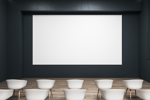 Front view on blank white wall board with space for your logo\
or text on black wall in empty auditorium with white seats on\
wooden floor 3d rendering mockup