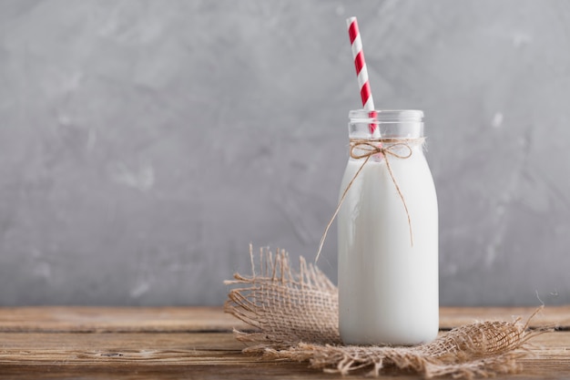 Front view bottle of milk with straw