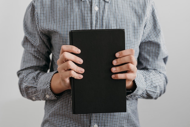 Ragazzo di vista frontale che tiene un libro sacro