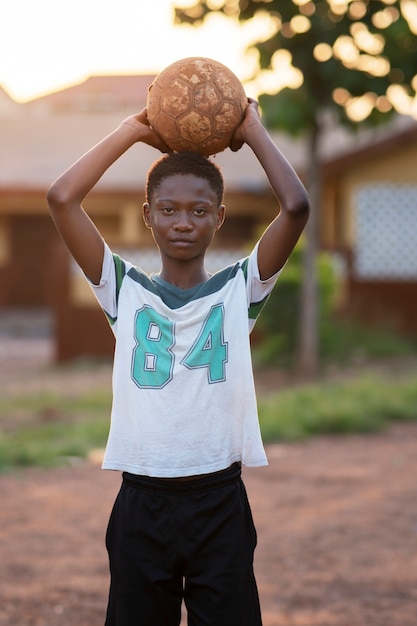 写真 ボールを持ち上げている正面図の少年