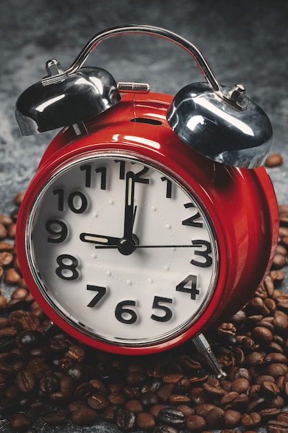 Front view of brown coffee seeds with red clocks dark surface