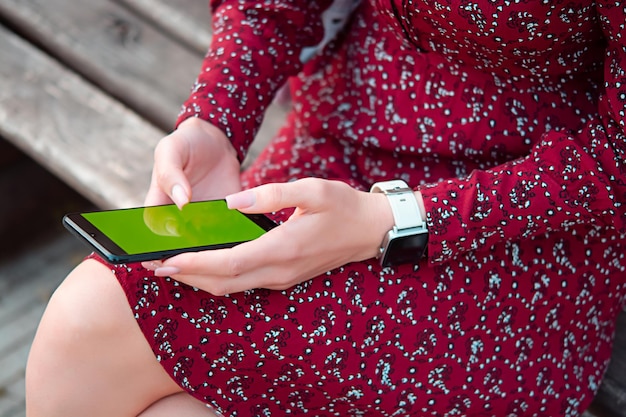 Front view of business happy young woman walking and using smartphone on city street a girl with