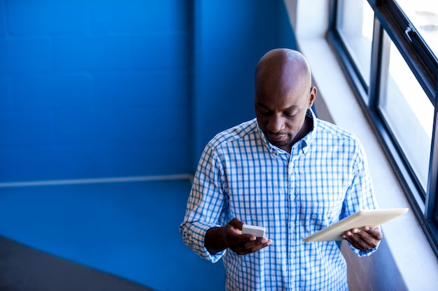 Front view of business man standing while using digital tablet