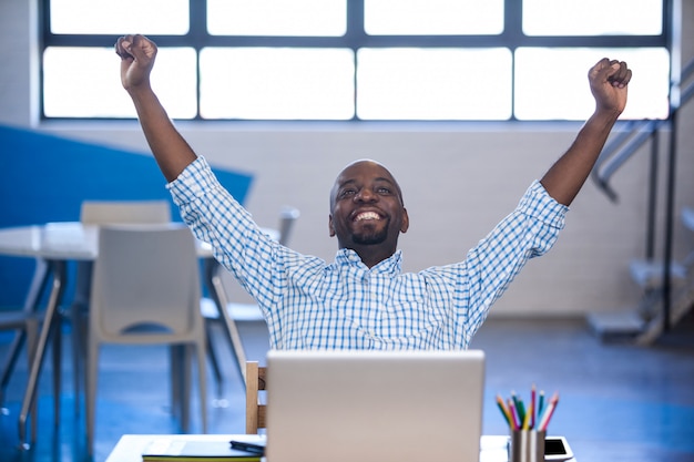 Front view of businessman celebrating success with arms up