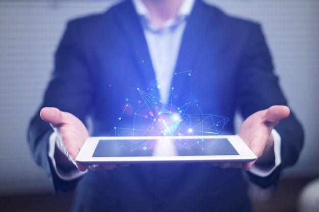 Front view of businessman holding high tech tablet