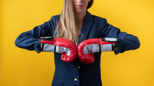 Photo front view of a businesswoman wearing red boxing gloves bumping fists together