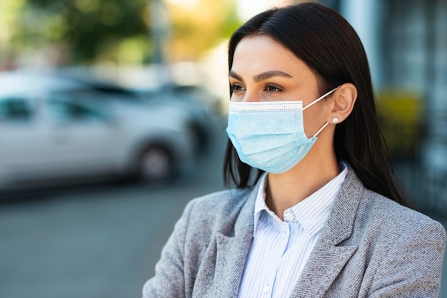 Foto vista frontale della donna di affari con maschera medica e copia spazio