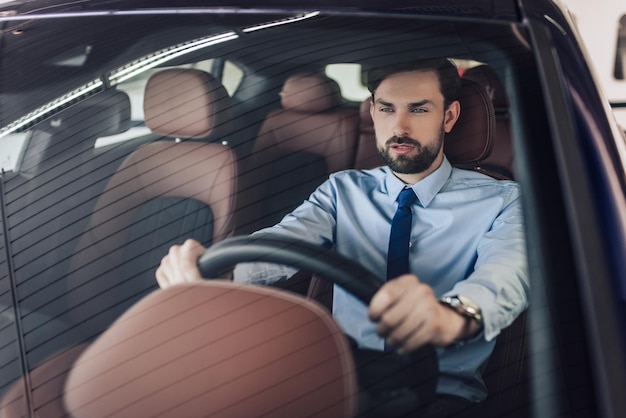 車を運転している白人の深刻なビジネスマンの正面図