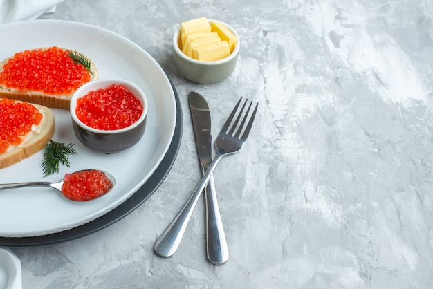 front view caviar sandwiches inside plate with cheese and cutlery on white surface