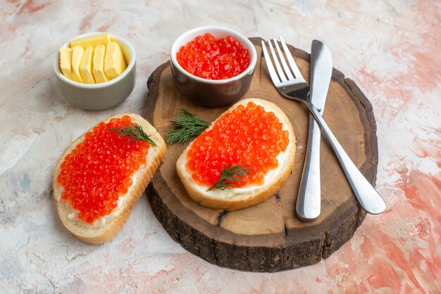 front view caviar sandwiches with cutlery and cheese on cutting board on light surface