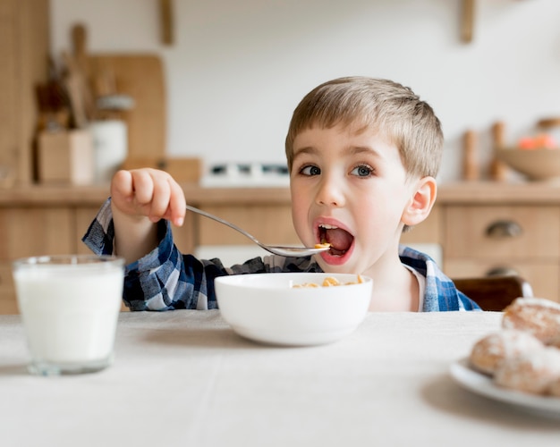 正面の子が牛乳が付いている穀物を食べる