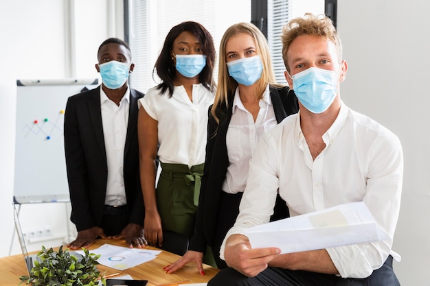 Foto vista frontale dei colleghi che lavorano durante il covid