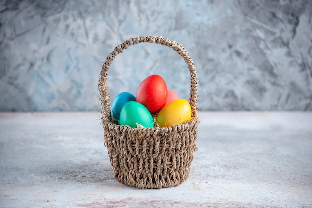 front view colored easter eggs inside basket on white surface