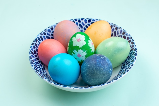 front view colored easter eggs inside plate on blue surface spring ornate multi colourful holiday ethnic colours easter