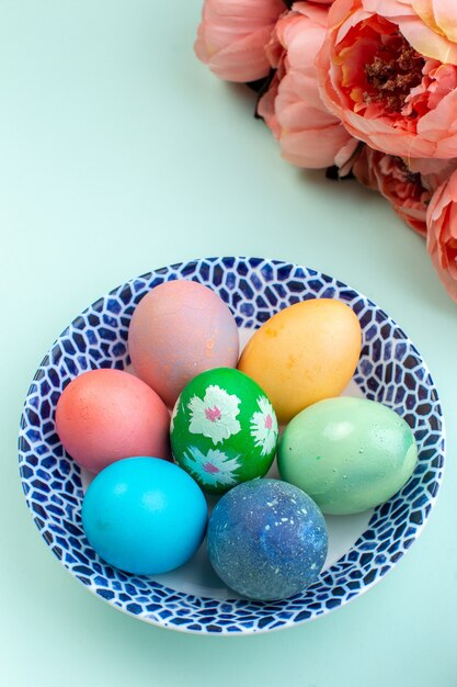 front view colored easter eggs inside plate on blue surface spring ornate multi colourful holiday ethnic easter