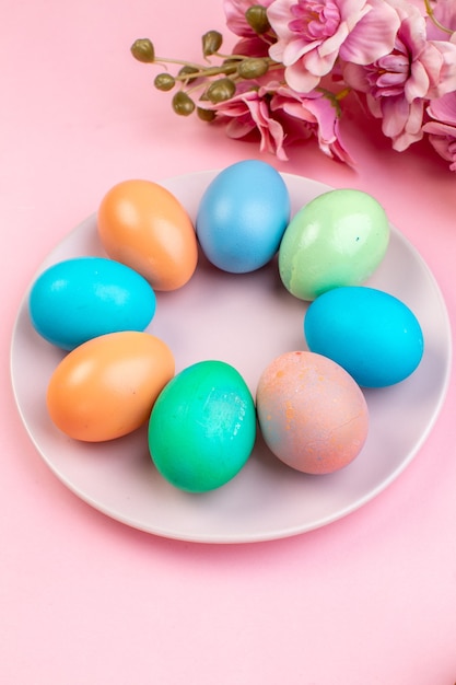 front view colored easter eggs inside plate on a pink surface holiday colourful spring concept ornate easter colour