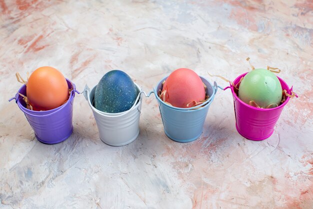 Front view colored easter eggs inside separate little baskets on light background ornate spring easter concept holiday colourful horizontal